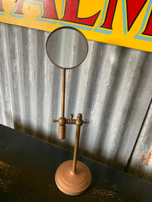 A vintage magnifying glass on a stand