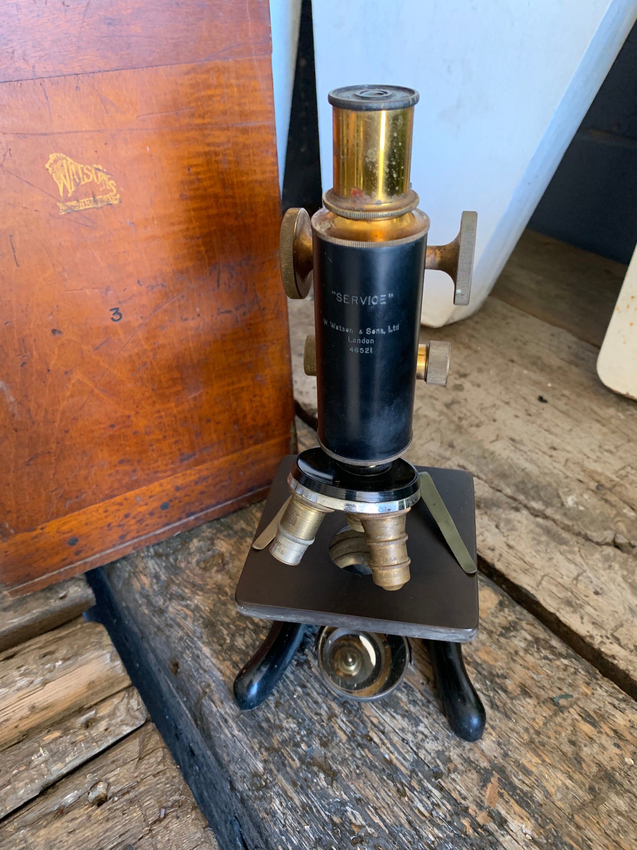 A Watson Service brass monocular microscope in original wooden case