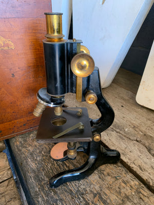 A Watson Service brass monocular microscope in original wooden case