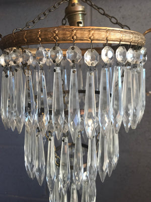 A gilt three tier crystal icicle droplet chandelier