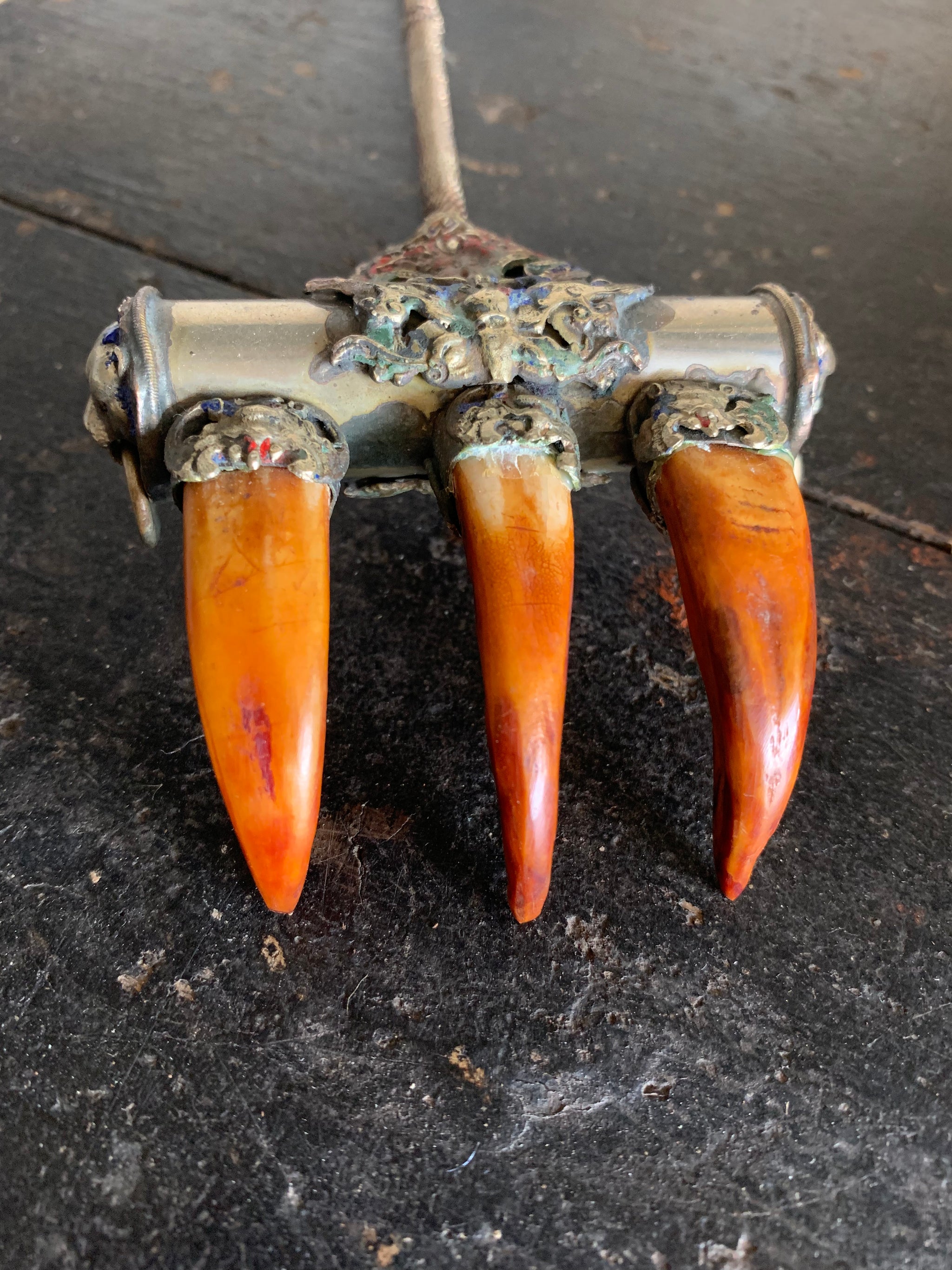 An enamelled Tibetan sliver claw back scratcher with bat and lion motifs