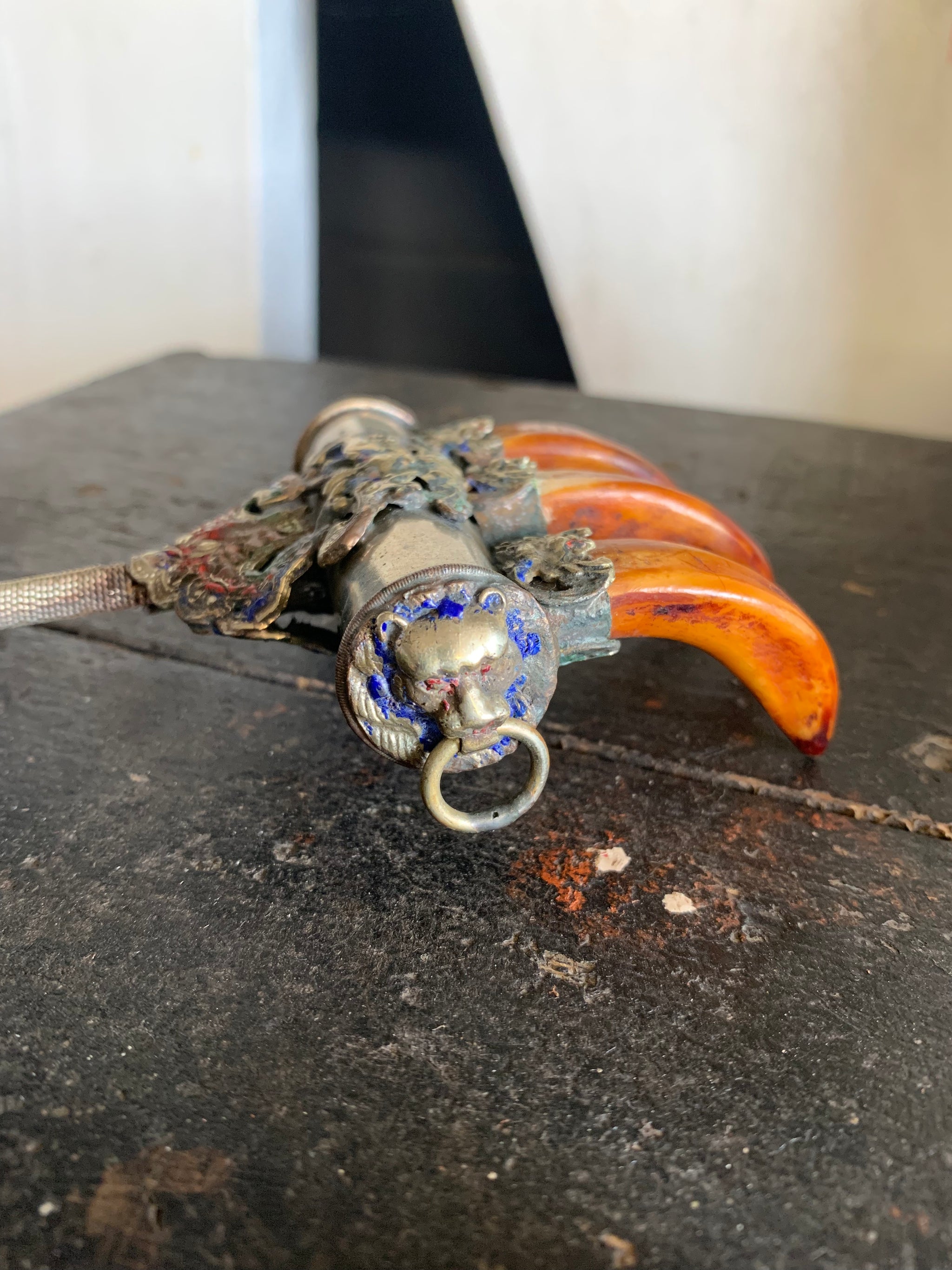 An enamelled Tibetan sliver claw back scratcher with bat and lion motifs