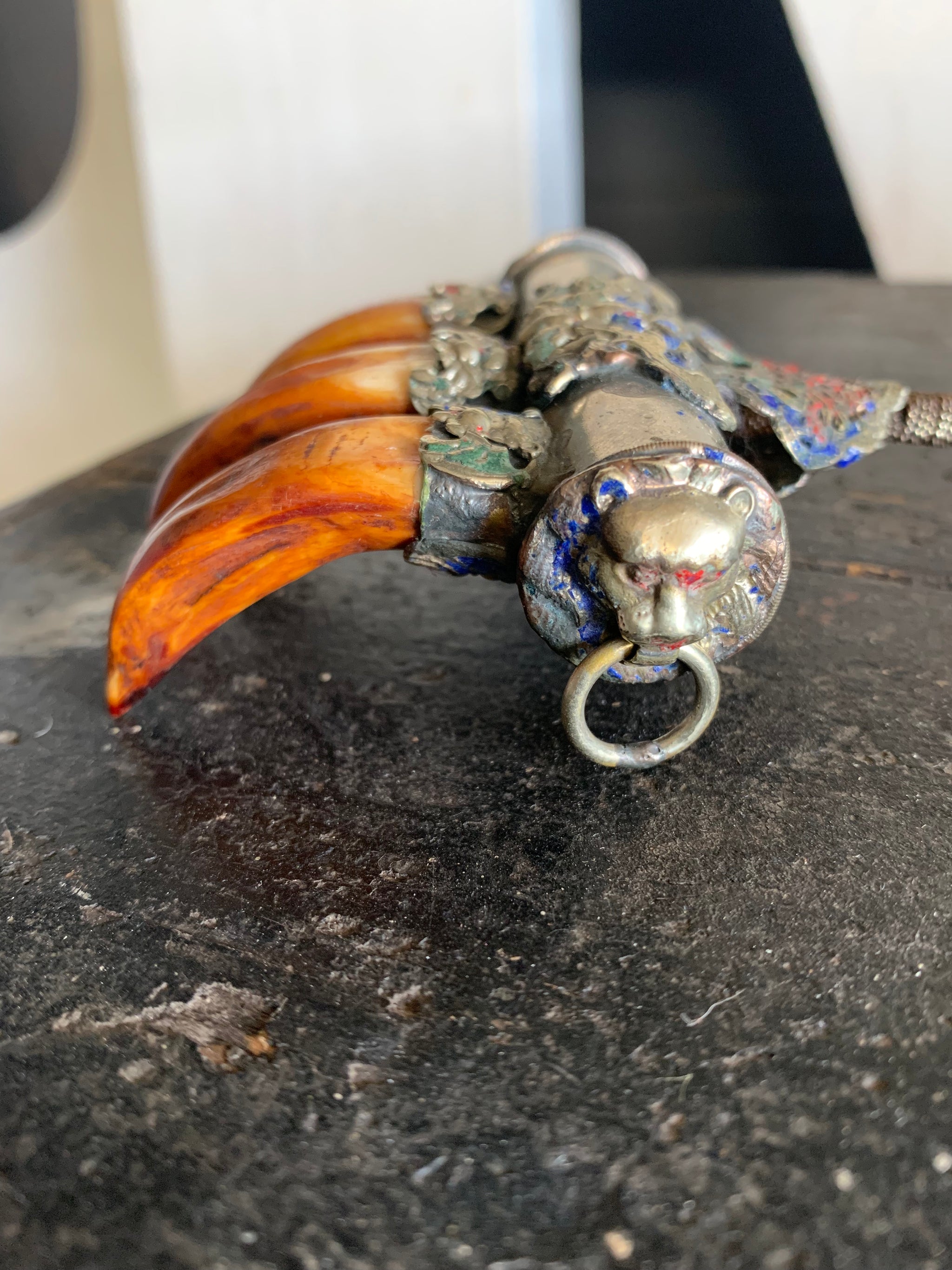 An enamelled Tibetan sliver claw back scratcher with bat and lion motifs