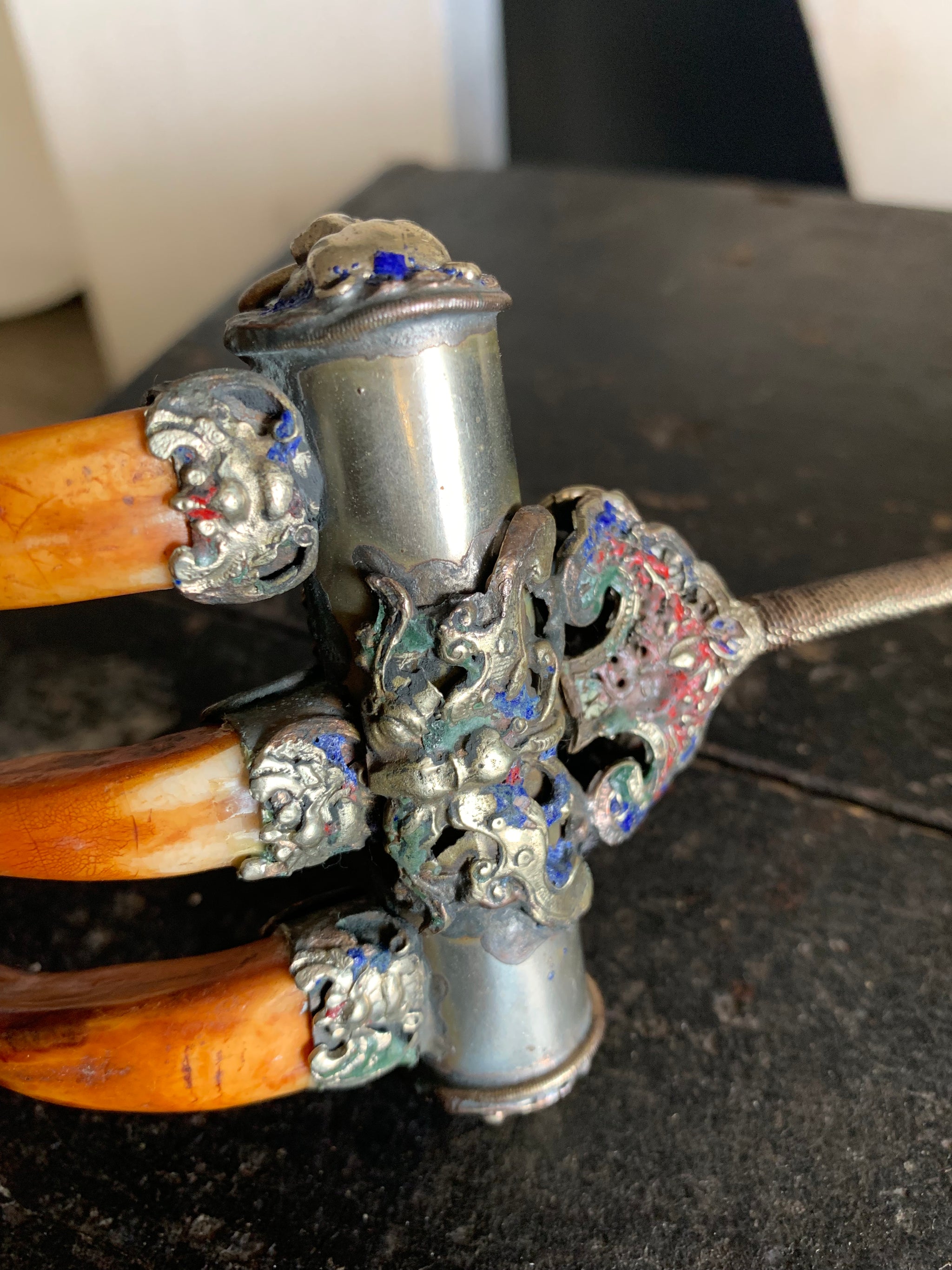 An enamelled Tibetan sliver claw back scratcher with bat and lion motifs