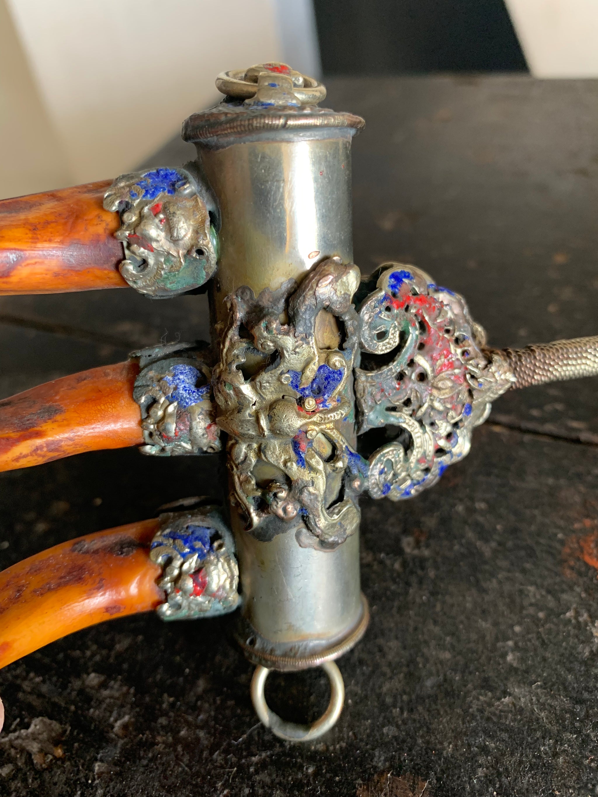 An enamelled Tibetan sliver claw back scratcher with bat and lion motifs