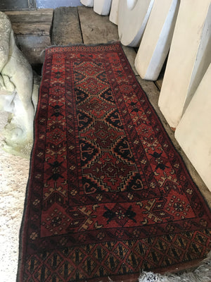 A short red ground Persian runner rug
