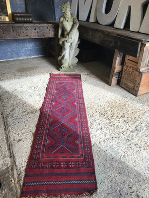 A long red ground Persian runner rug