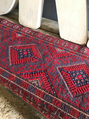 A long red ground Persian runner rug