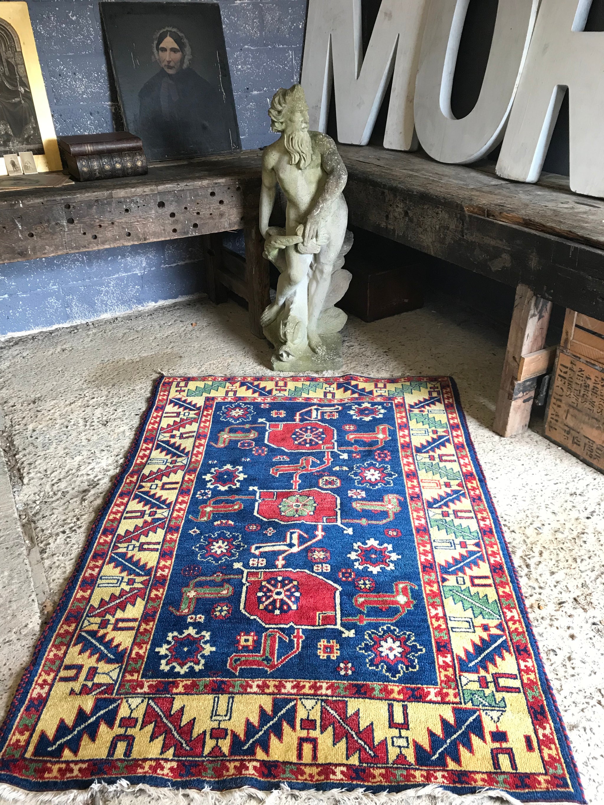 A large rectangular blue and yellow Kazak rug