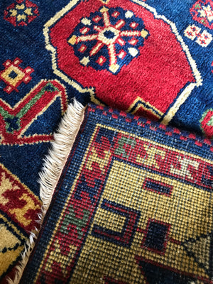 A large rectangular blue and yellow Kazak rug