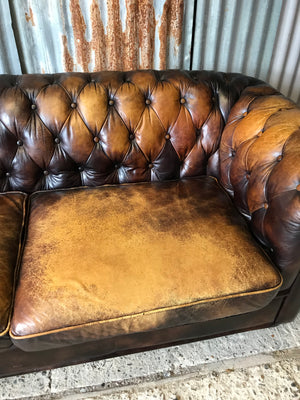 A brown leather three seater button back Chesterfield sofa