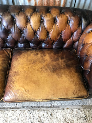 A brown leather three seater button back Chesterfield sofa