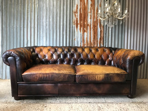 A brown leather three seater button back Chesterfield sofa