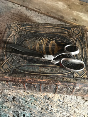 A pair of large metal tailor's scissors shears