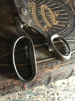 A pair of large metal tailor's scissors shears