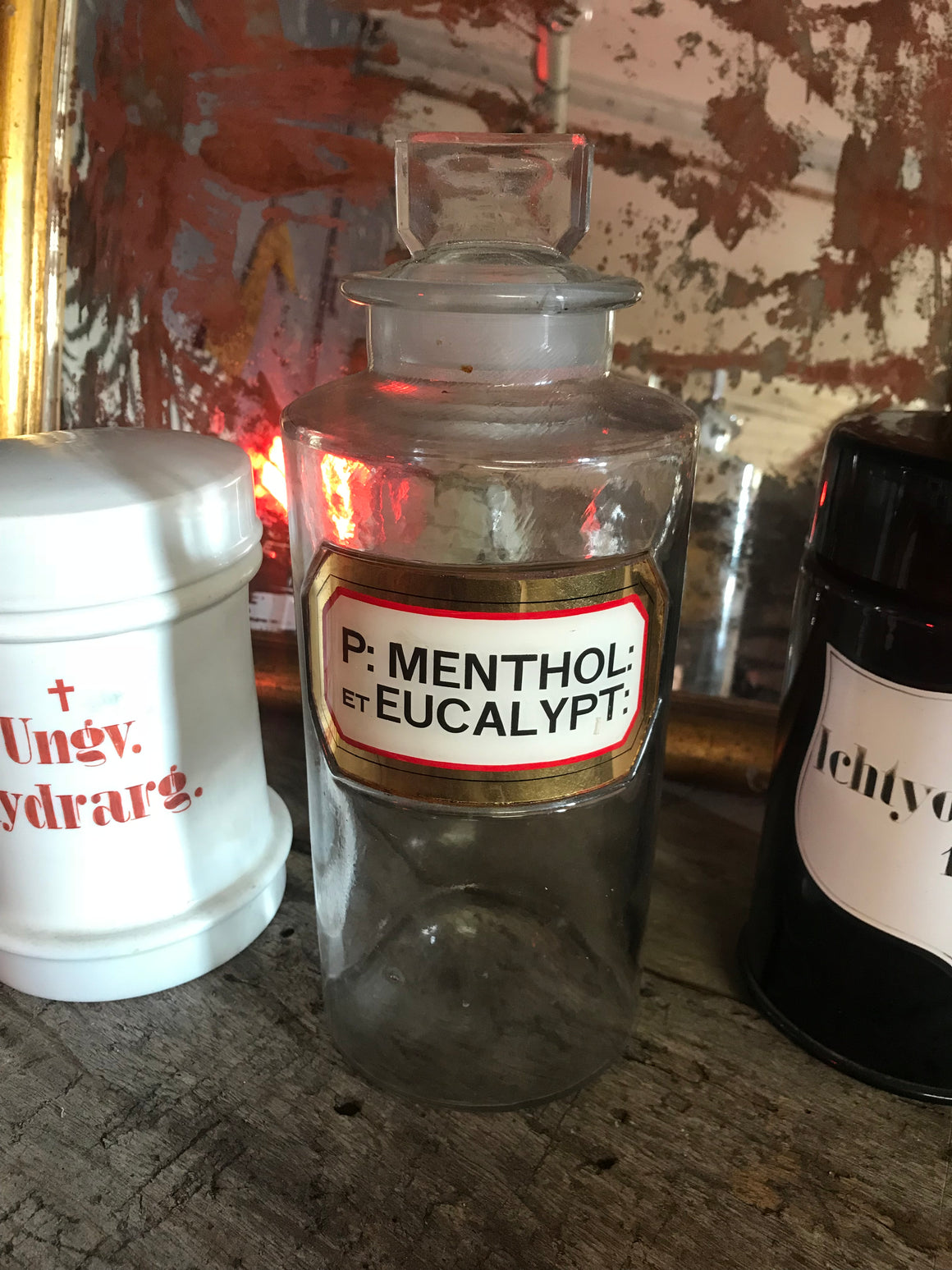 A large glass apothecary jar with hand painted gold leaf label