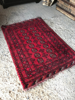 A large rectangular red Persian hand knotted wool carpet 157cm X 107cm