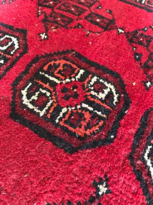 A large rectangular red Persian hand knotted wool carpet 157cm X 107cm