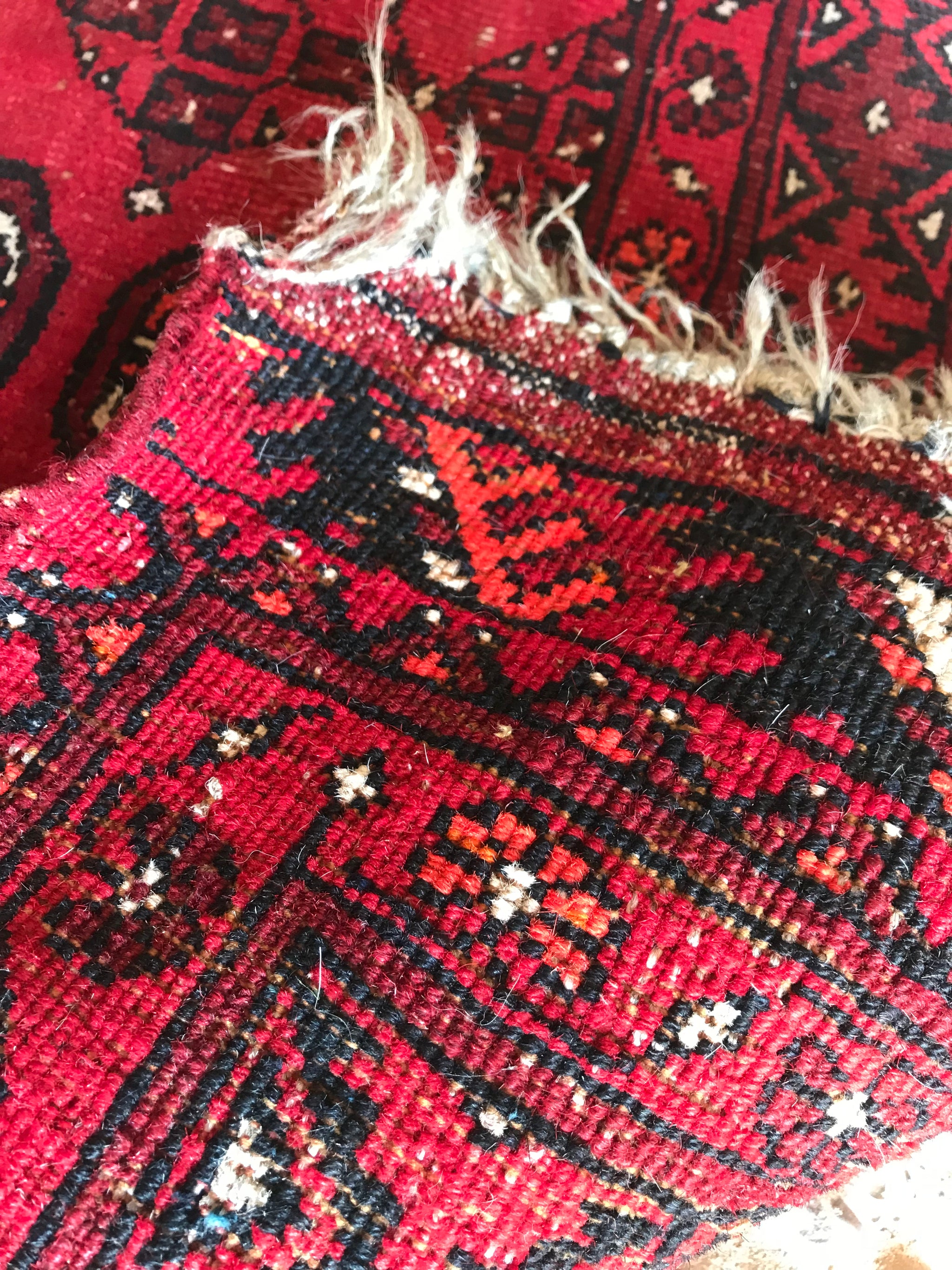 A large rectangular red Persian hand knotted wool carpet 157cm X 107cm