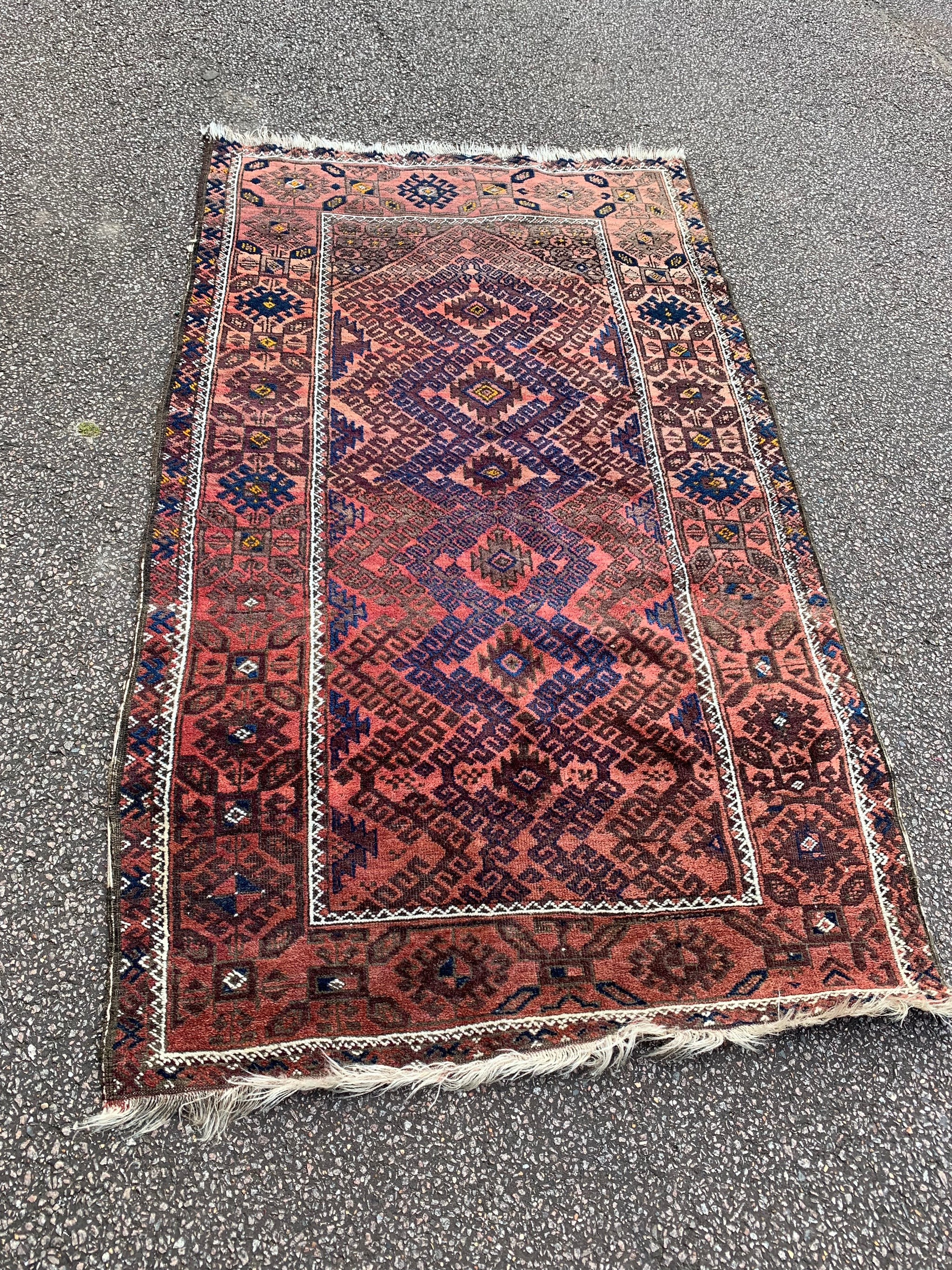 A large rectangular red brown ground Persian rug