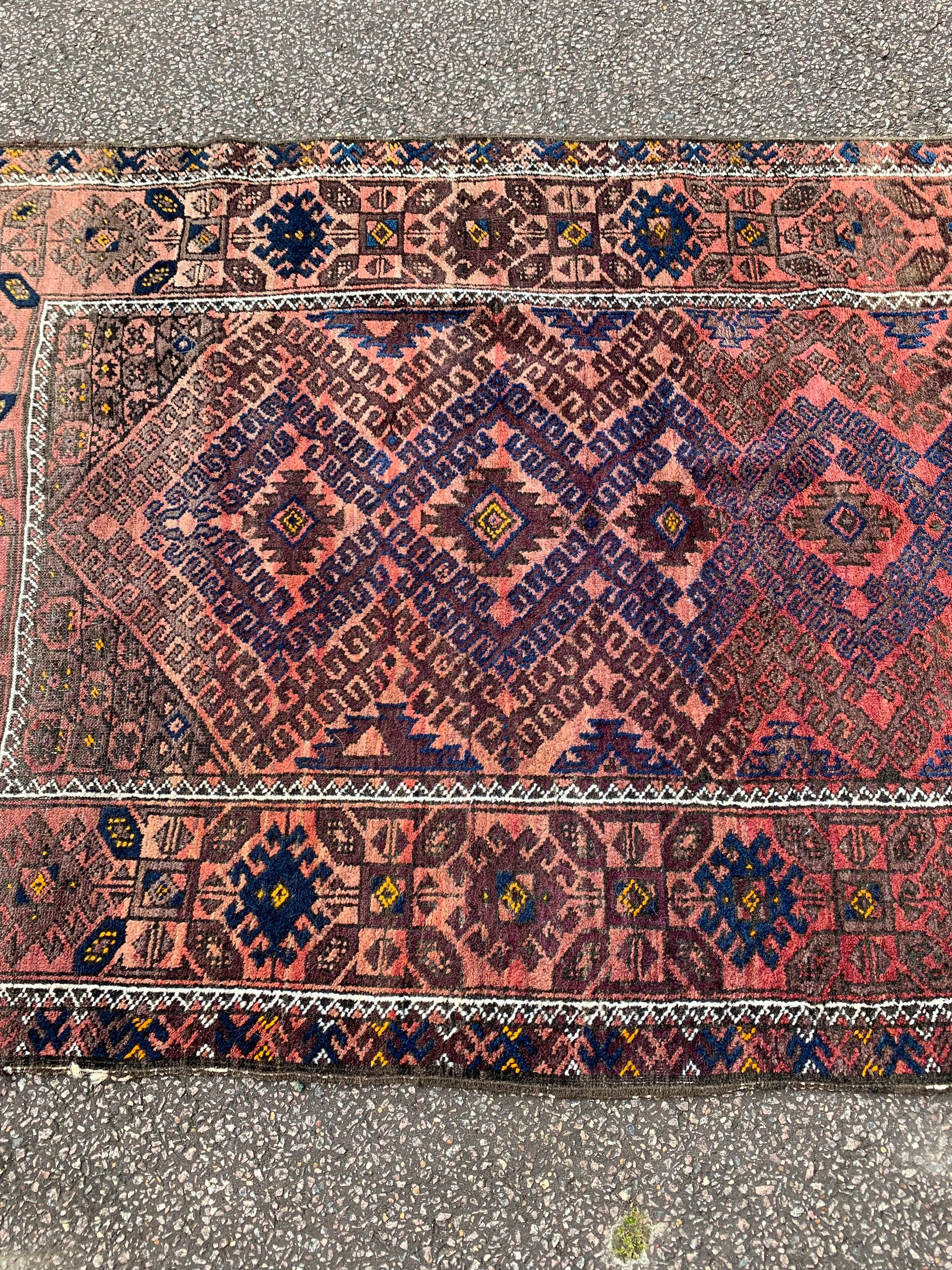 A large rectangular red brown ground Persian rug
