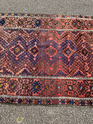 A large rectangular red brown ground Persian rug