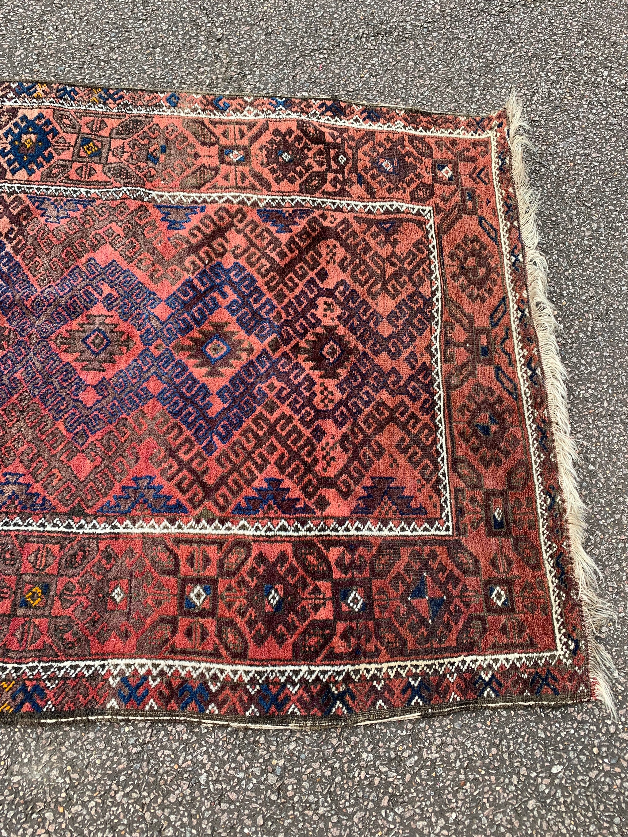 A large rectangular red brown ground Persian rug