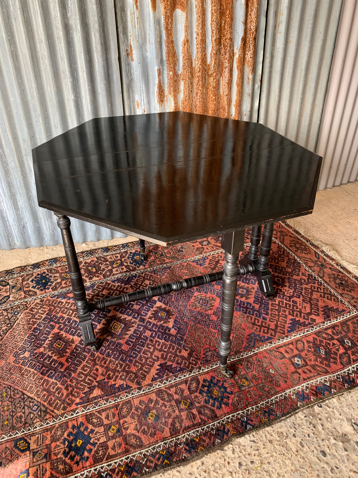 An ebonised drop leaf octagonal Sutherland table