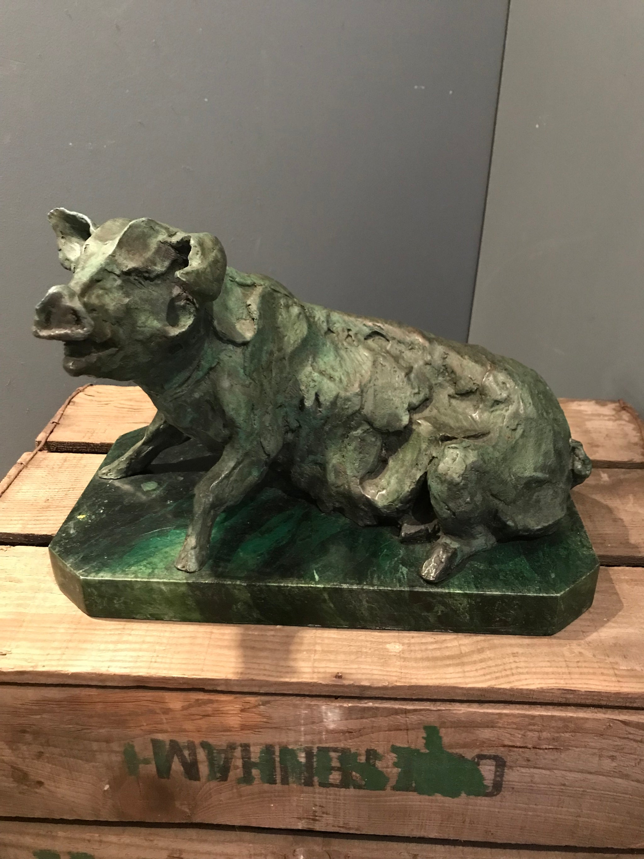 A verdigris bronze cire perdue pig sculpture on a green marble base