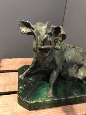 A verdigris bronze cire perdue pig sculpture on a green marble base