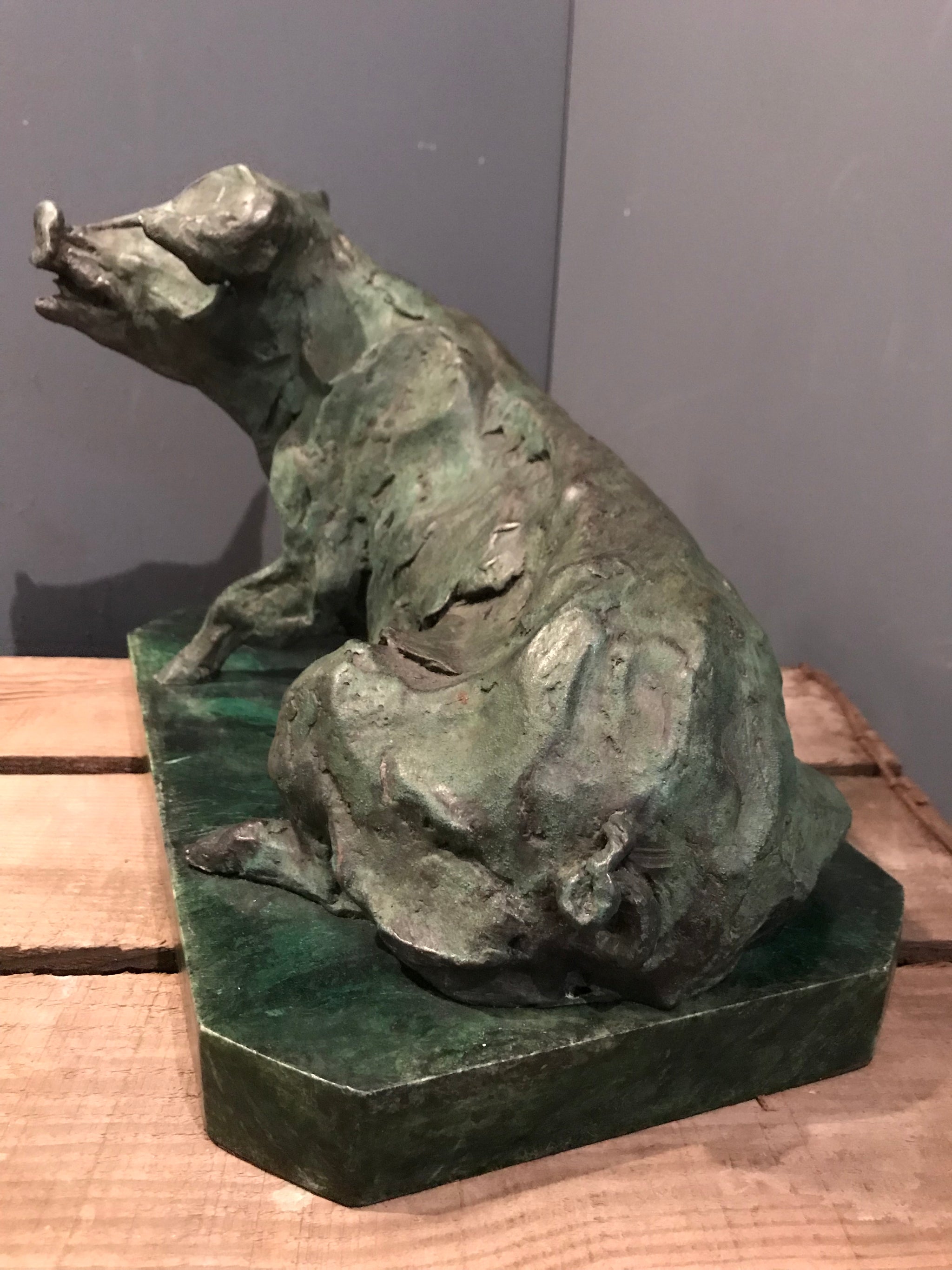 A verdigris bronze cire perdue pig sculpture on a green marble base