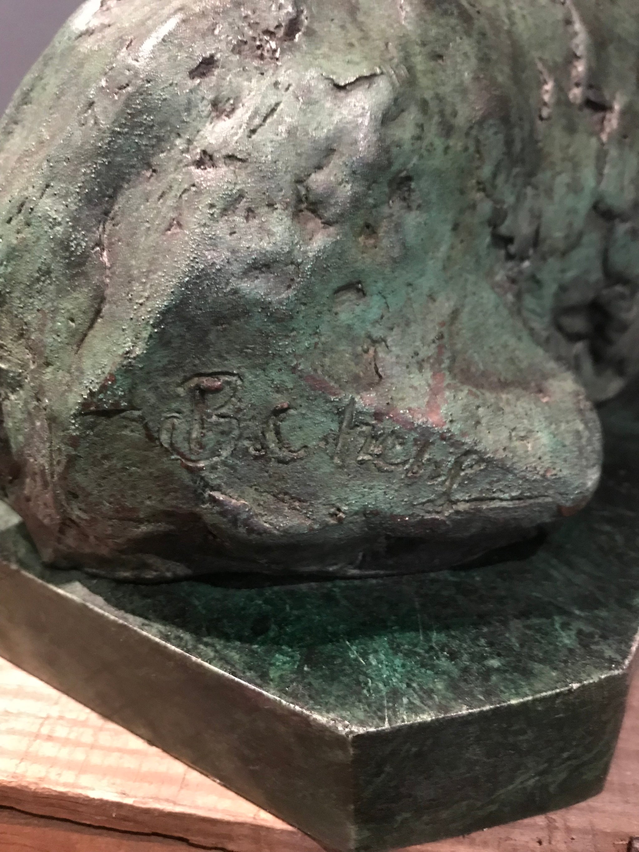 A verdigris bronze cire perdue pig sculpture on a green marble base