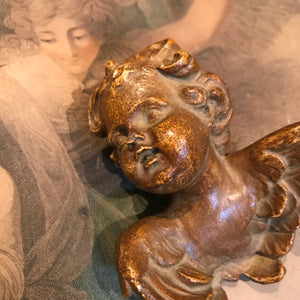 A pair of ceramic wall hanging winged putti busts