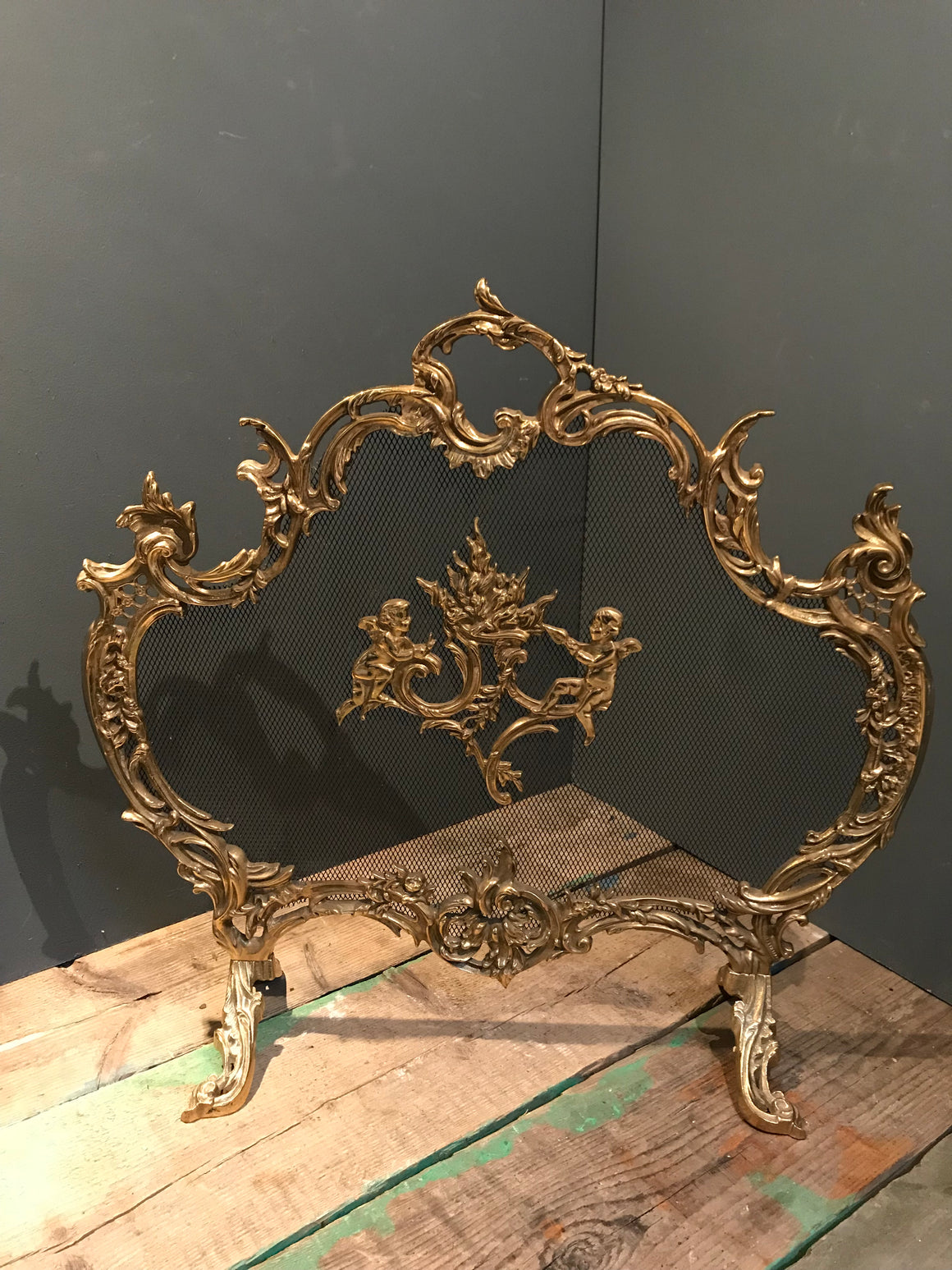 A Rococo style ornate brass and mesh firescreen
