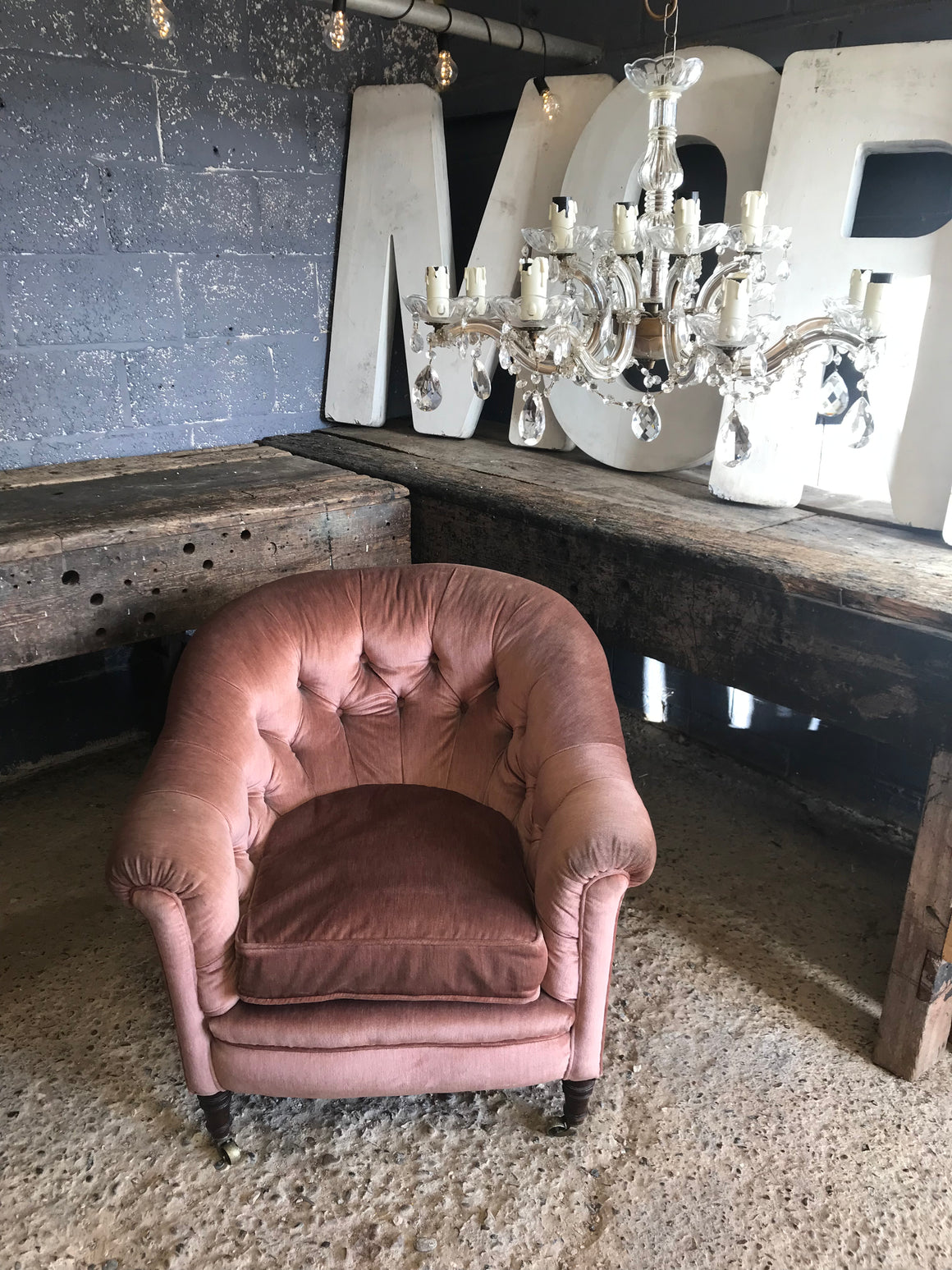 A pink velvet Hollywood Regency/Art Deco button back chair with brass castors