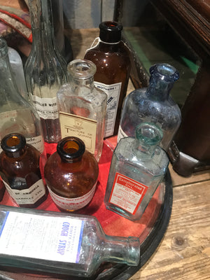 A collection of apothecary bottles and jars on a velvet base