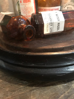 A collection of apothecary bottles and jars under a glass dome