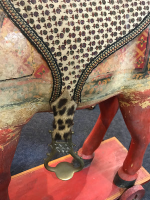A large 19th Century Persian polychrome painted rocking horse on wheels