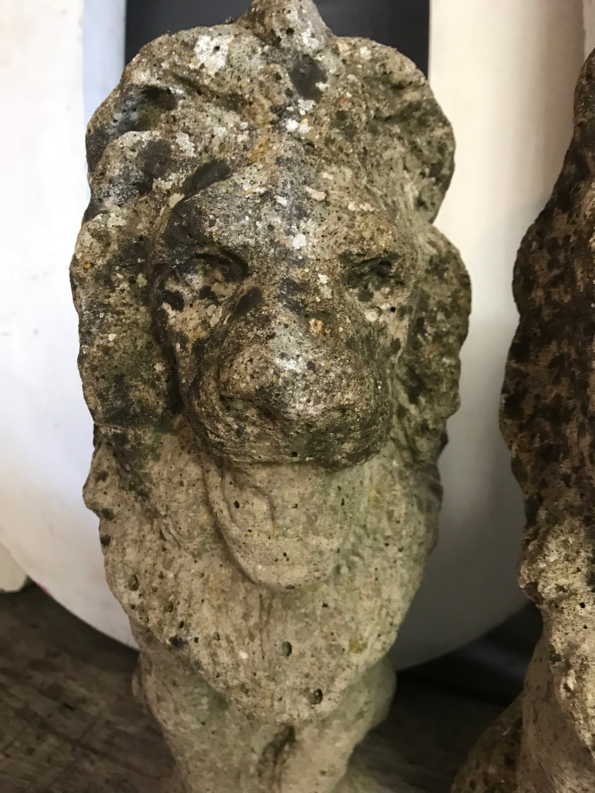 A pair of weathered cast stone lion statues