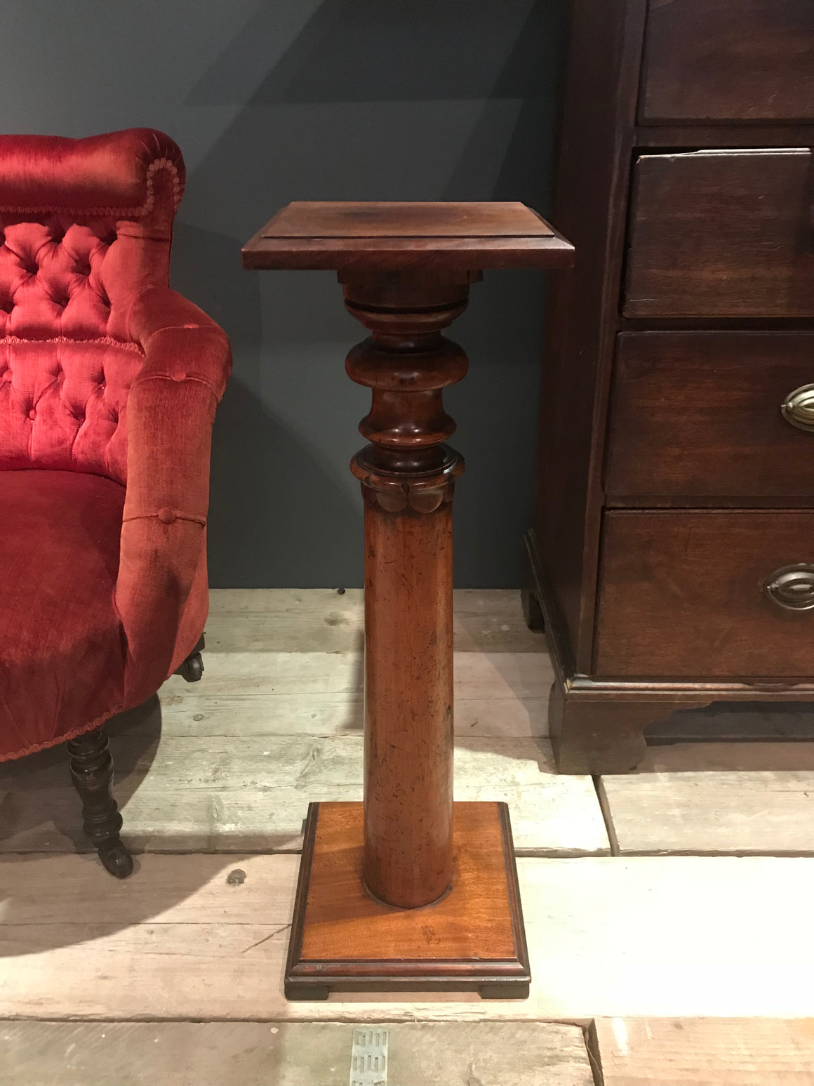 A small wooden torchere display stand with acanthus leaf detail