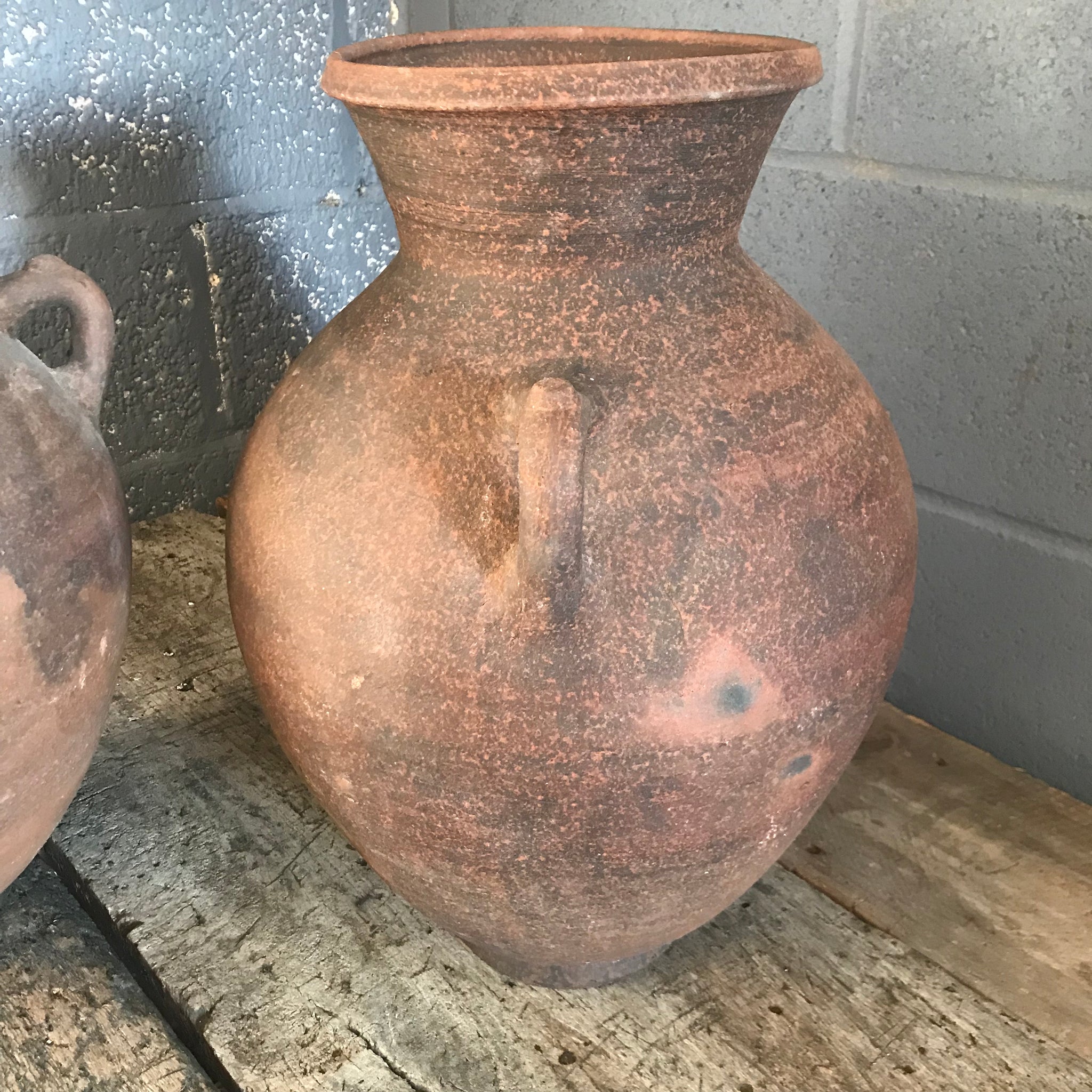 A pair of large terracotta urns with double lug handles