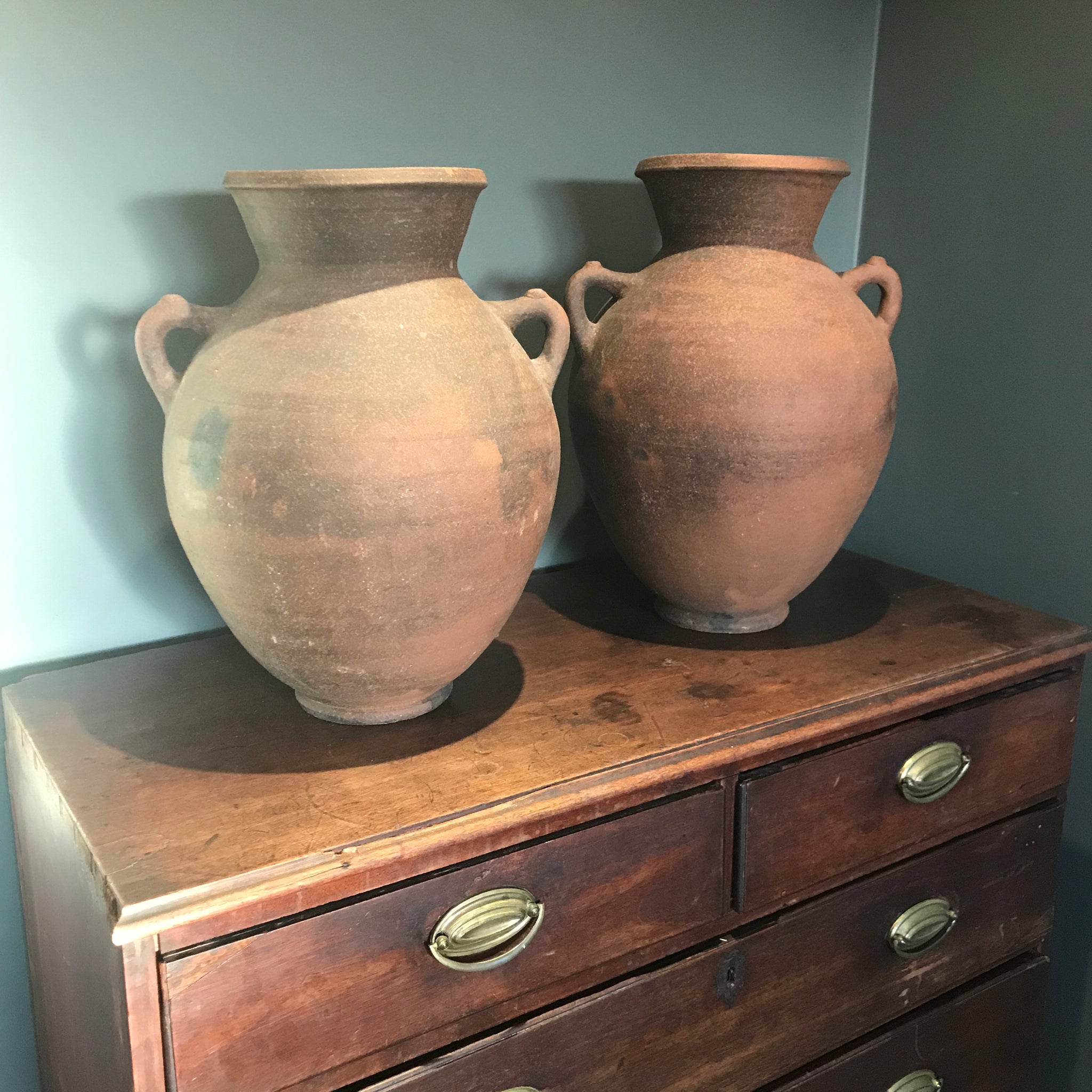 A pair of large terracotta urns with double lug handles