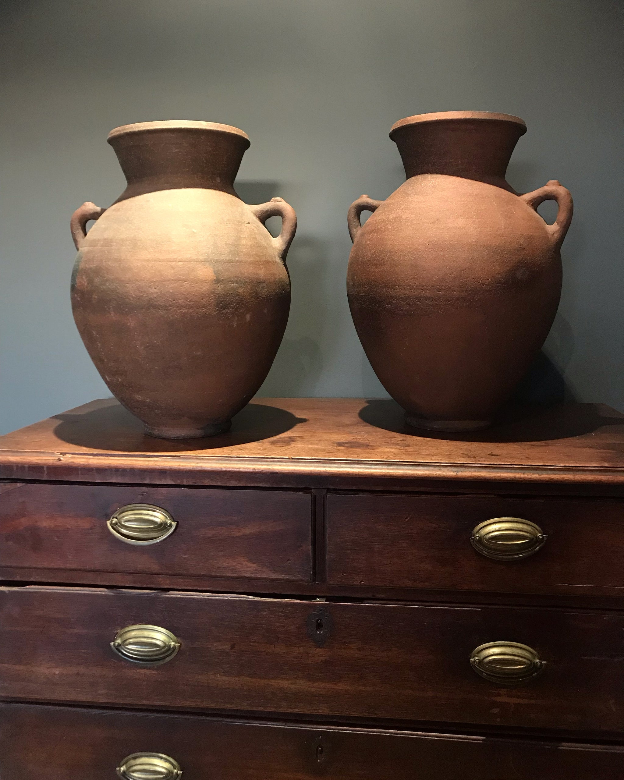 A pair of large terracotta urns with double lug handles