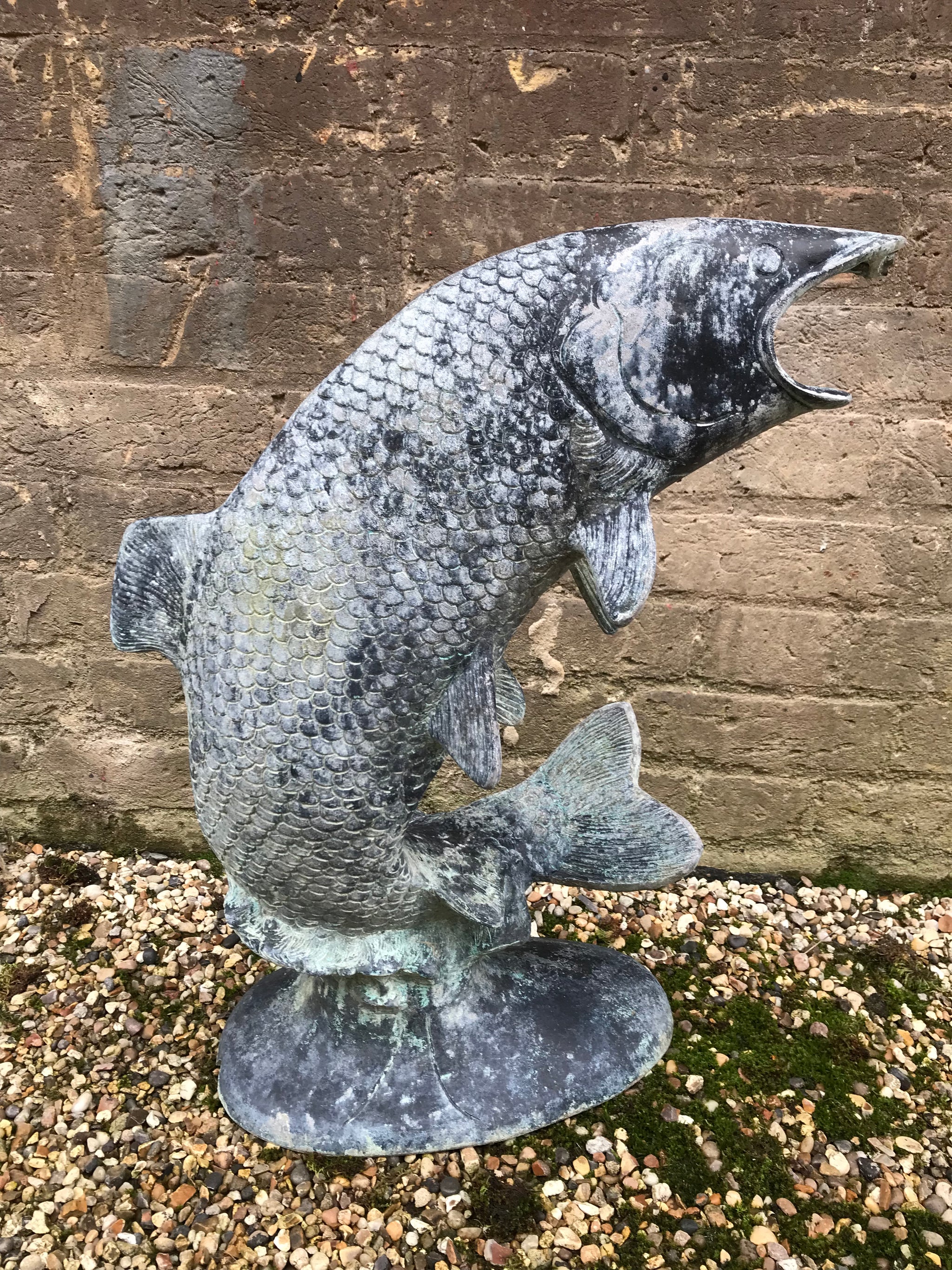 A sculptural copper verdigris leaping carp fountain