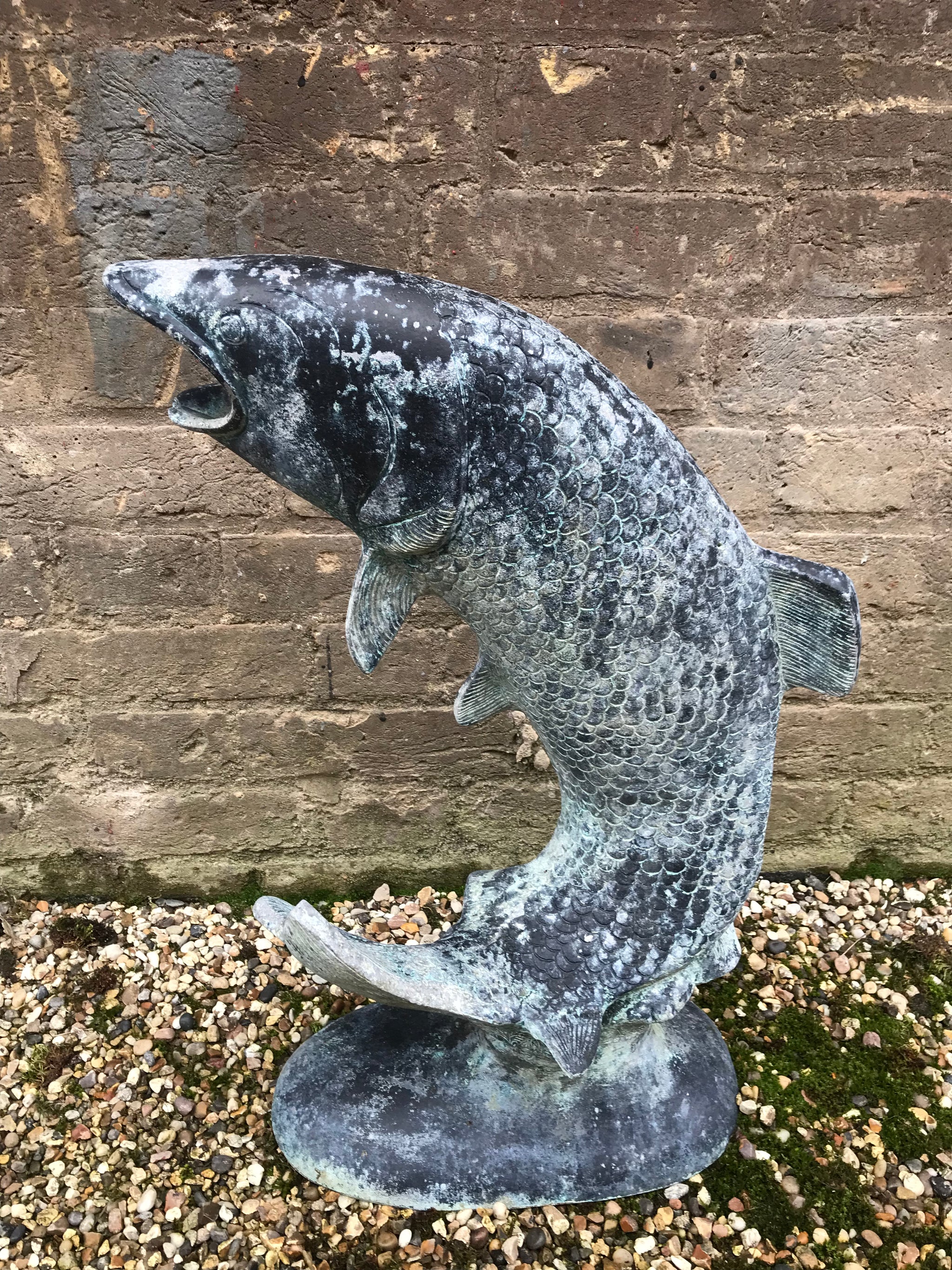 A sculptural copper verdigris leaping carp fountain