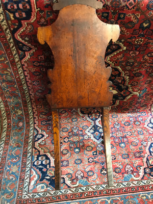 A 19th Century carved wood hall chair with monogrammed armorial crest