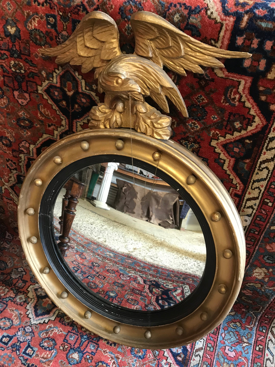 A Regency gilt convex ball and chain eagle mirror