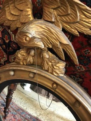 A Regency gilt convex ball and chain eagle mirror