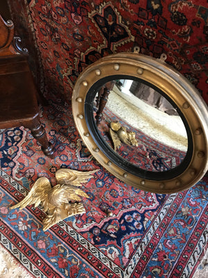 A Regency gilt convex ball and chain eagle mirror