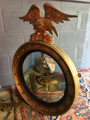 A Regency gilt convex ball and chain eagle mirror